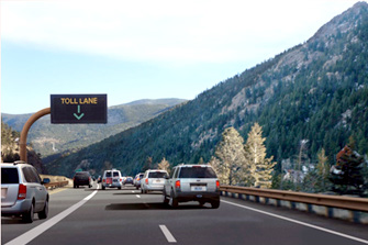 Photo shows open dynamic part-time shoulder, indicated by a sign with a green arrow and toll lane message.