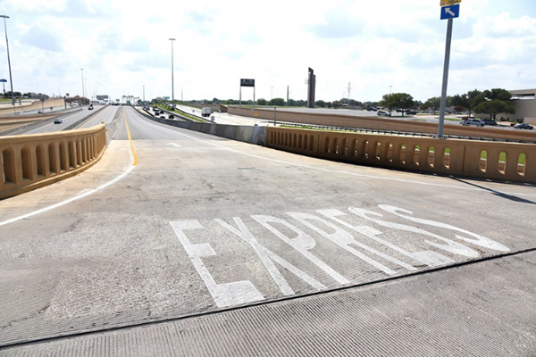 An entrance ramp in Dallas, Texas that directly connects an overpass to managed lanes the operate in the freeway median.  The word 'Express' is shown in white striping on the ramp.