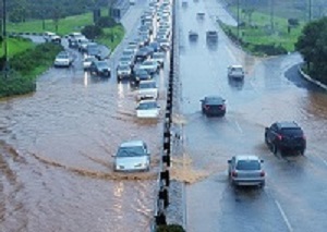 Pictures show cars merging onto a roadway into a heavily flooded road.