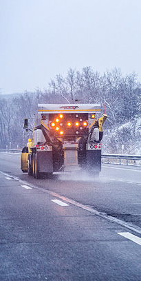 A snow plow driving down a road.