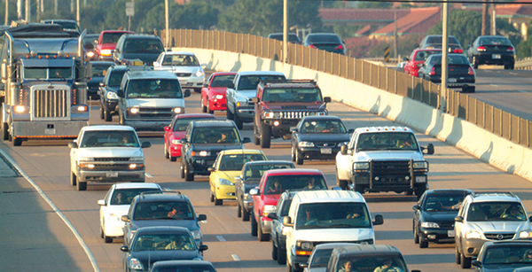 Photo showing three lanes of traffic on a busy freeway.