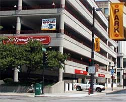 photo showing a designated off-street parking garage, as noted by a light post banner, for a downtown planned special event
