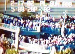 image from a CCTV showing a crowd of spectators crossing a pedestrian bridge