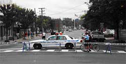 photo showing a police cruiser and Type 1 barricades blocking access to a local street
