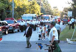 photo showing a group of parade participants congregating on a residential road and intersecting road