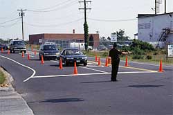 photo showing a police officer, located in the center of an intersection, directing approaching traffic to turn left