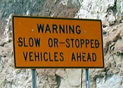 photo showing a road sign displaying the message "warning – slow or stopped vehicles ahead"