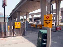 photo of area reserved for special event bicycle parking under an urban highway overpass. The area is marked with signs stating "Summerfest Bicycle Lot"