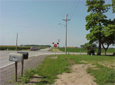 photo of a roadway with a stop sign visible in the distance with red flags on the top left and right of the sign