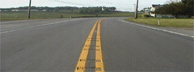 photo of raised horizontal strips across yellow centerline in roadway
