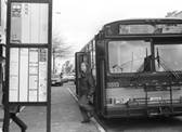 Photograph:    Transit bus stopped at a bus stop.  A passenger is shown having just walked off the bus.  