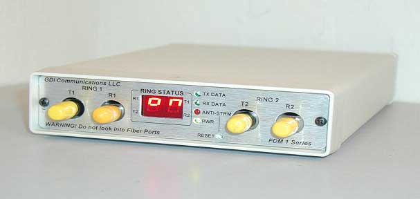 photograph of a basic fiber optic modem used for traffic signal control systems, with lights for T1, R1, T2, and R2 and a window showing ring status