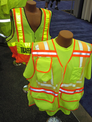 Photo of two fluorescent yellow-green safety vests, one sleeveless and one with sleeves, with horizontal and vertical retroreflective tape