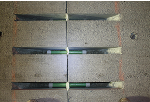 Photo depicts a slab containing a standard wide mouth dowel. The wide mouth dowel slots are saw cut through the top of any slabs, chipped out and then the dowels set on chairs across the joints before being backfilled with high early strength mortar.