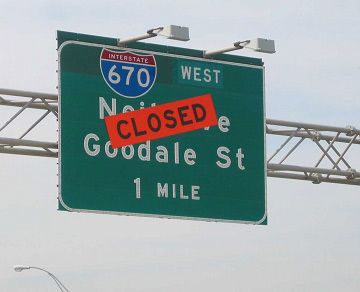 photo of overhead highway sign for Interstate 670 west with a Closed banner across the street name