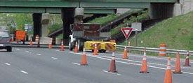 work vehicle and cones on highway