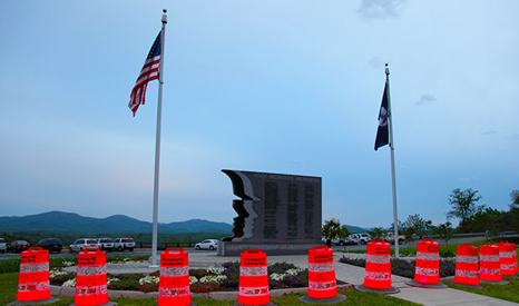 The VDOT Workers Memorial Wall surrounded by illuminated traffic barrels.