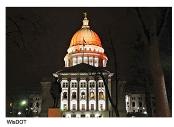 Dome of the RIDOT state house illuminated with orange light.