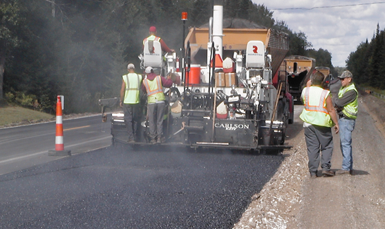 Asphalt being laid down by a construction vehicle.