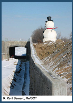 Overpass featuring a large snowman to the side of the road. Photo credit: R. Kent Barnard, Minnesota DOT.