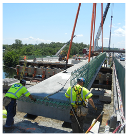 Workers placing a precast deck panel.