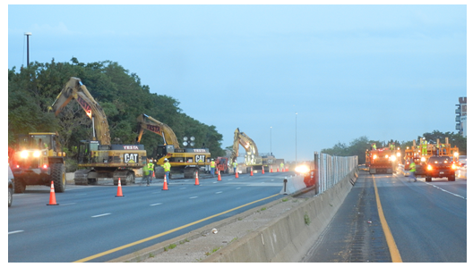 Photo depicts road work getting underway at dusk.