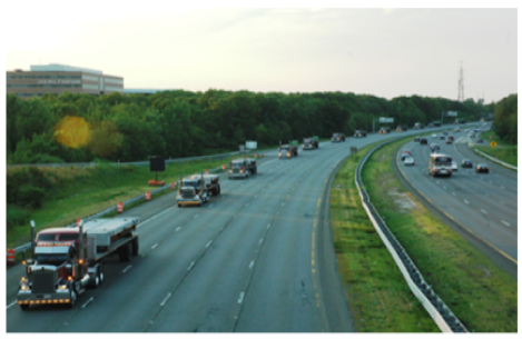 Convoy of flatbed trucks on the interstate transporting precast materials to the work zone.