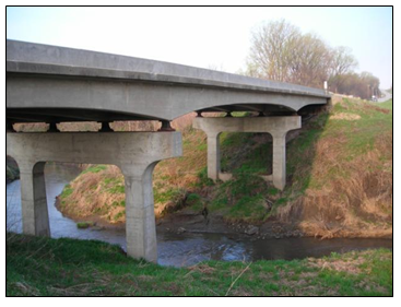 Photo of a rural bridge over a stream.