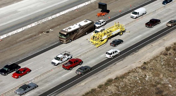 Aerial photo of a zipper truck moving a row of moveable concrete barriers.