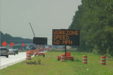 A work zone with a dynamic message sign displaying 'Workzone Speed 60 MPH'