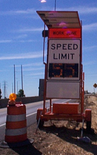 A dynamic speed limit sign powered by a solar panel in a work zone.