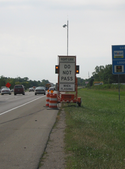 Portable message sign reads 'Right Lane – Do Not Pass When Flashing' sign in a work zone.