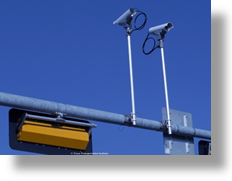 Two cameras mounted on a street sign structure.