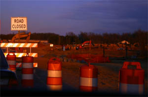 View of a construction site with barriers and a sign that reads "Road Closed"
