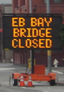 Photo of portable sign on roadway with the message "EB Bay Bridge Closed"