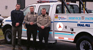 Photo of officers standing in front of a service patrol truck.