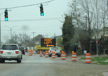 Photo of a portable changeable message sign next to a roadway displaying a left-pointing arrow below the message "Keep Left."