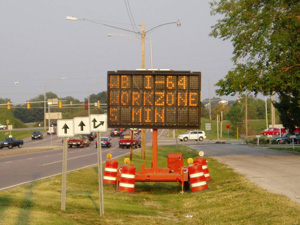 portable sign displaying the message "WB I-64 workzone 5 minutes"