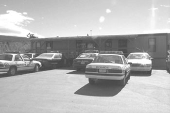 Figure 6 - This figure shows a number of police cruisers parked outside the temporary police substation in the general contractor's staging yard.