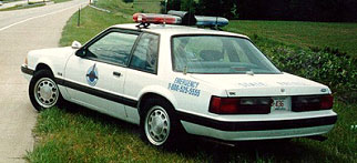 photo of police car parked next to roadway
